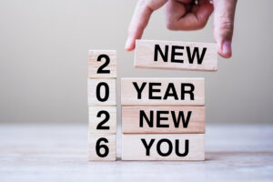 Hand holding wooden block with text 2026 NEW YEAR NEW YOU on table background. Resolution, strategy, goal, business and holiday concepts