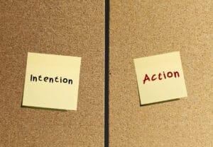 Notes stick on wall INTENTION and ACTION to Go From Intention to Action and Skip the Excuses start moving toward to future actually want.