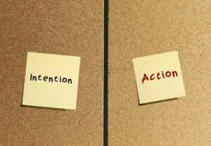 Notes stick on wall INTENTION and ACTION to Go From Intention to Action and Skip the Excuses start moving toward to future actually want.
